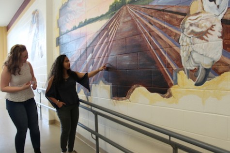 El Nesr and sophomore Bridey McGlynn explain the mural.