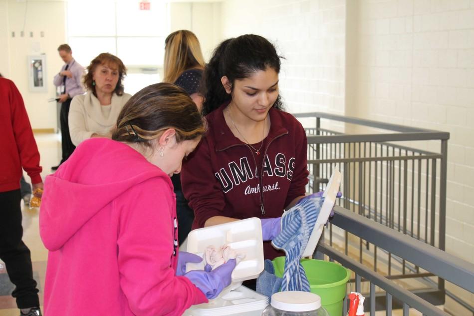 Volunteers Hayley Lyons and Anushka Dasgupta (left to right) clean trays during lunch.