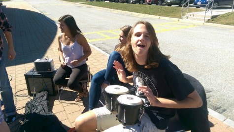 Junior Michael Dutko slams on the bongos beside the Algonquin acoustic club.