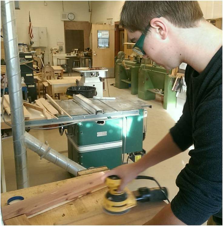 Senior Jon Cahill sands a cutting board during a Wood Tech class.