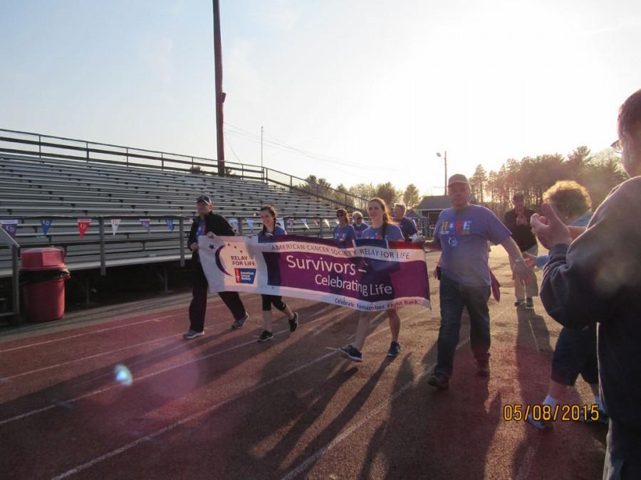 Cancer+survivors+carry+the+banner+on+the+first+lap+of+the+relay.