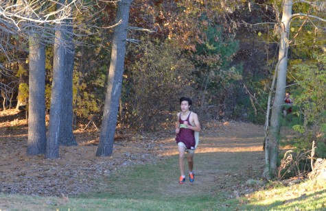 Junior Noah Brazer emerges from the woods in a meet against Westborough. He finished in third with a time of 16 minutes and 52 seconds