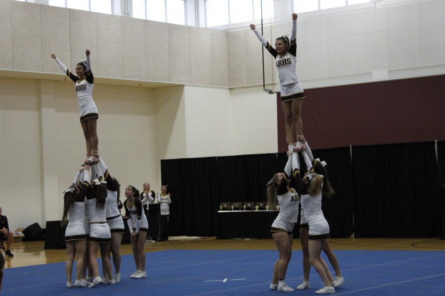 Cheerleaders hold up sophomore flyers Tiffany Filadelfo and Nicole Wales at the state competition on November 22.