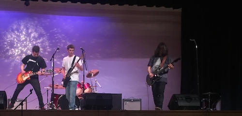 Dirty Mike and the Boys members seniors Mike McCormack, John Baroosian, and junior Dan Mac Donald rock out on stage. 