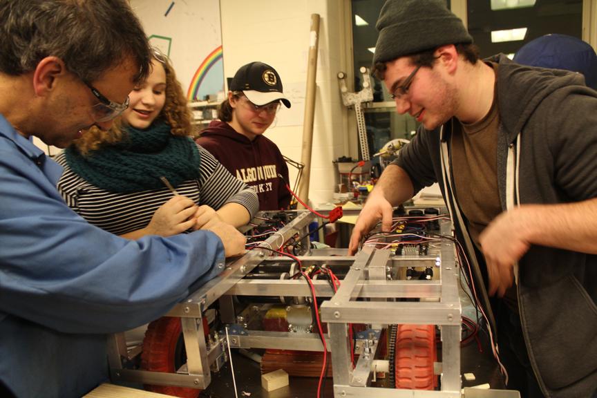 During the build season, Team 1100 members including senior Justin Stott (right) collaborate to construct their robot.