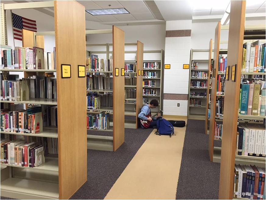 Junior Bobby Raps practices his bass guitar in the quiet library.
