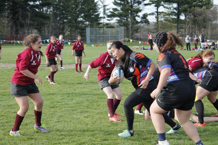 Senior captain Rachel White (left) prepares to assist her teammate junior Maddie Scott during their 60-12 victory over Newton on April 27.