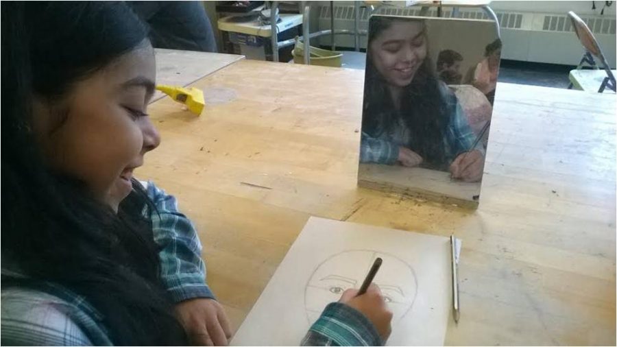 As her self-portrait begins to look more and more like her, freshman Priyanka Joshi smiles to herself in her Art I class.  