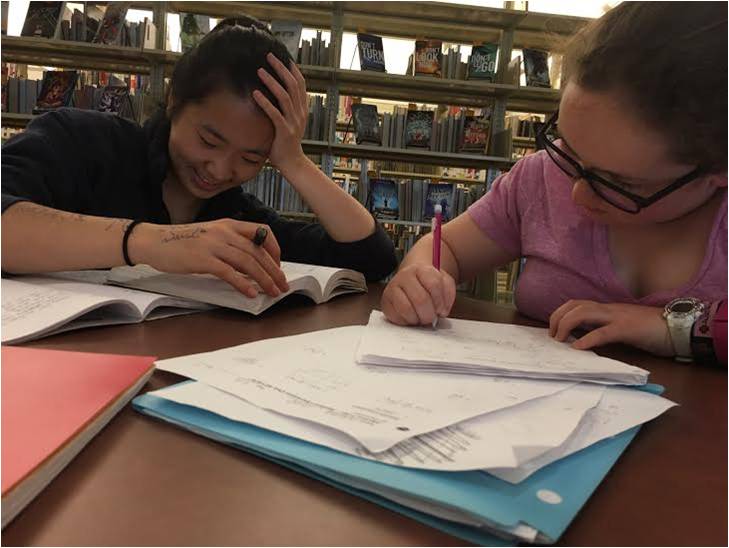 Between the end of school and the start of sports, freshmen Hailey Lowe and Nellie Zhang get some homework done in the library.


