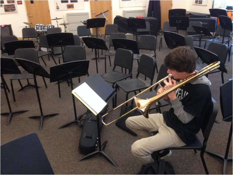 Found playing during a free third period, senior Eric Coughlin practices the trombone in the band room.
