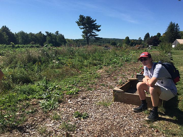 Senior Max Donahue sits in a garden at Overlook Farm.