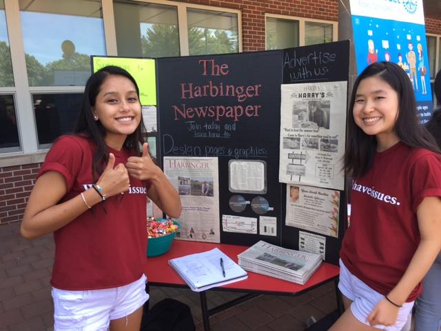 Editor-in-chief Riya Pujari and News editor Cassidy Wang pose by the Harbinger Newspaper display. Go Harbinger!