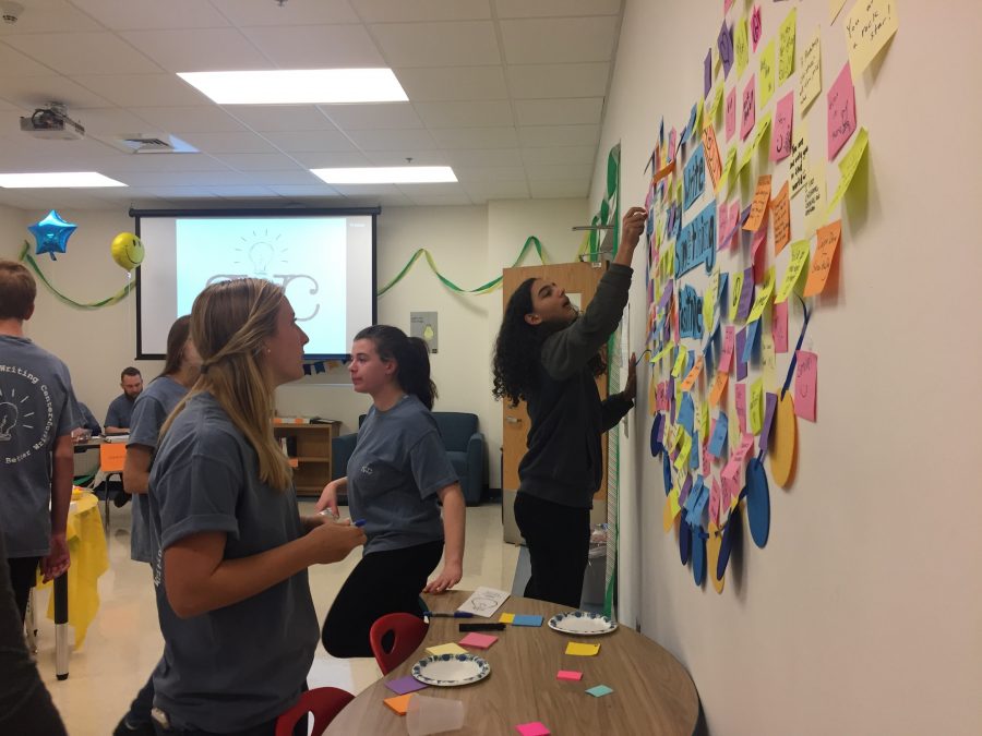 Students paste positive notes to the wall, which consist of encouraging words. 