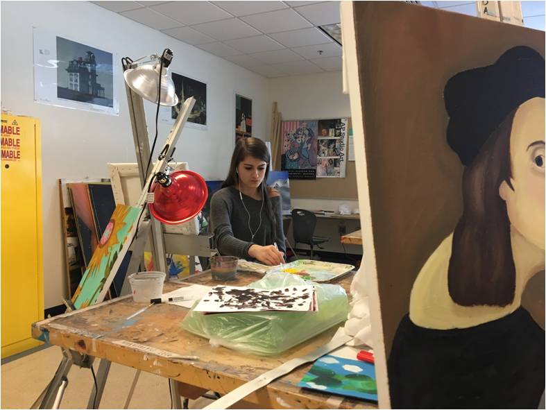 Dipping her brush in acrylic, senior Advanced Art I student Brooke Goguen works on her latest assignment.
