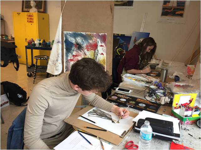 Seniors Max Donahue and Kate Hostage peacefully paint their original pieces for art class.