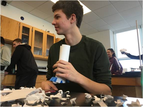 Junior Nick Carulli watches his physics peer test their toy car bumpers for effectiveness, as he continues to perfect his own.