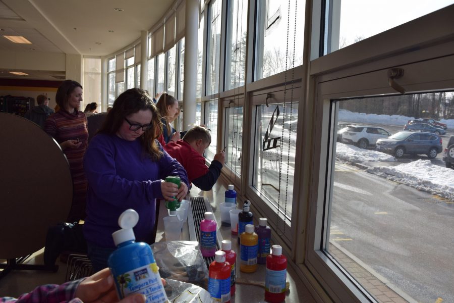 Best Buddies club members paint the cafeteria windows during their after school meeting for the annual Friendship Ball on February 17.