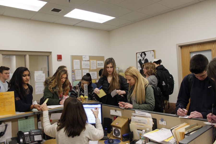 A morass clogs the upper school office as students fill out tardy slips at the beginning of school.