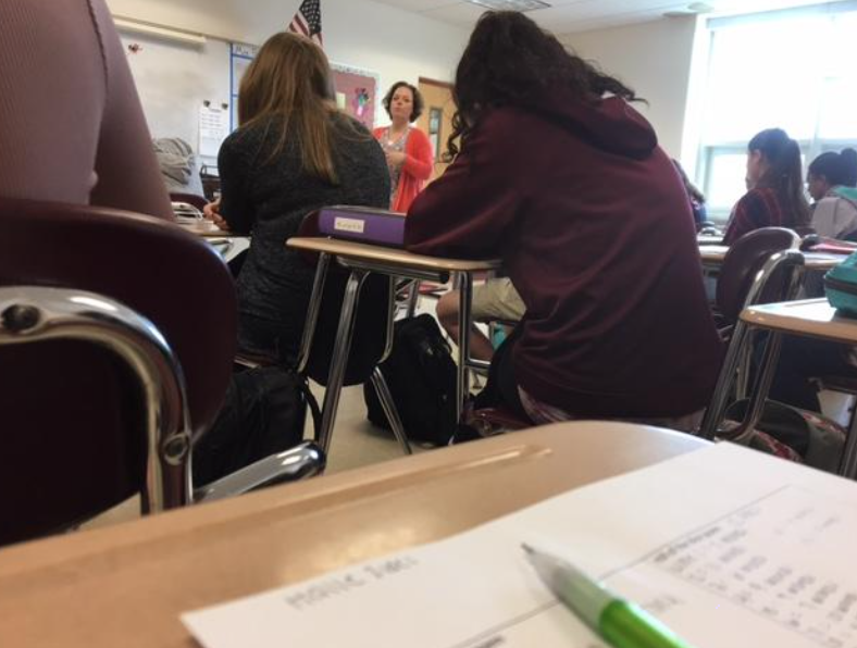 English teach Rebecca Pratt teaches her freshman students as they take notes while she lectures them on the book “How the Garcia Girls Lost their Accents.”
