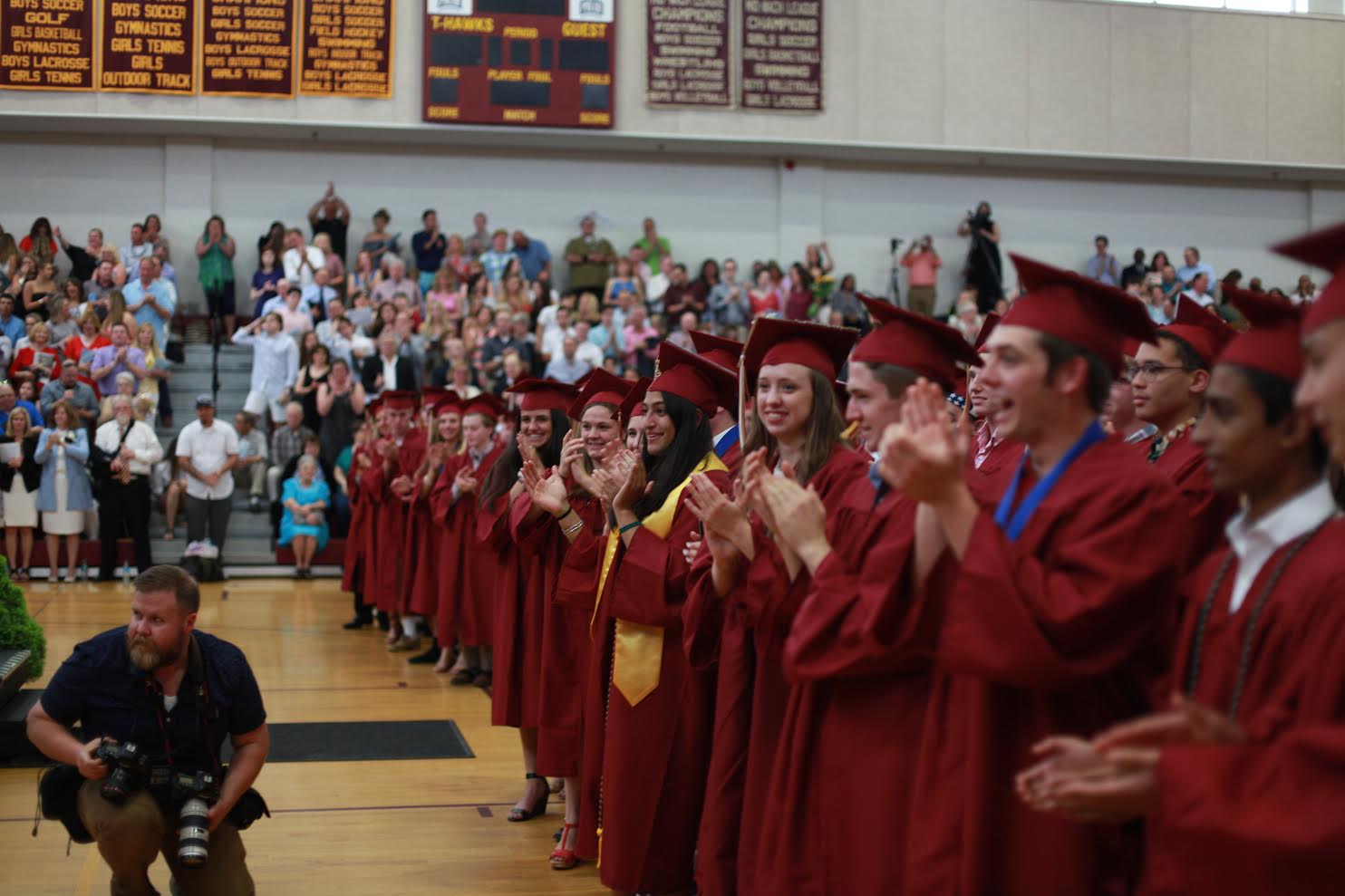 The graduates stand up for a round of applause after a speech. 