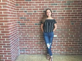Freshman Kristy Simopoulous pairs an off the shoulder top, ripped jeans, and Birkenstocks to create a trendy outfit for the summer.
