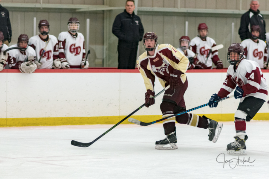 Senior captain Nate Anderson keeps his eye on the puck at the Groton-Dunstable game on February 3. 