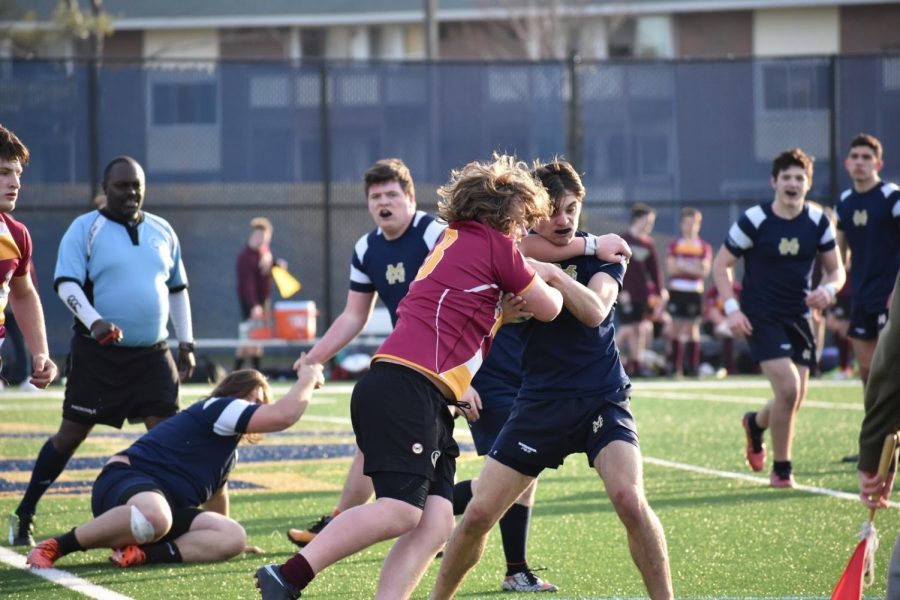 Sophomore Mike Cowdrey plows through other players as he protects the ball.
Malden Catholic wins, 20-5 with scoring four tries (worth 5 points each).

