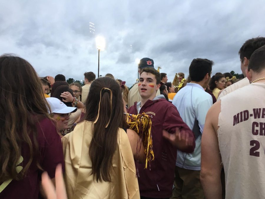 Senior Kevin Reddington pushes through the crowd of students eagerly waiting to rush the football field.