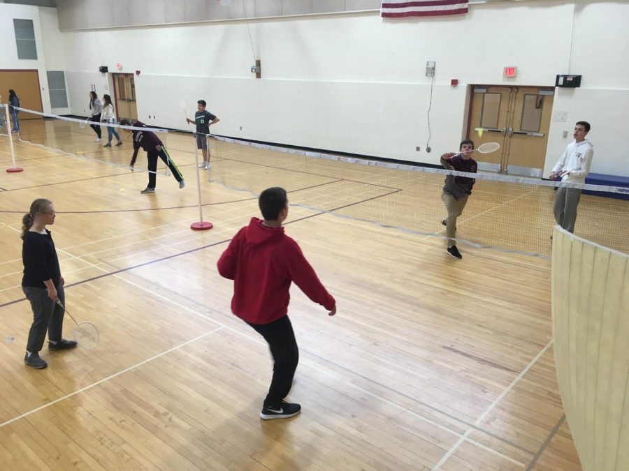 A sophomore gym class plays badminton.