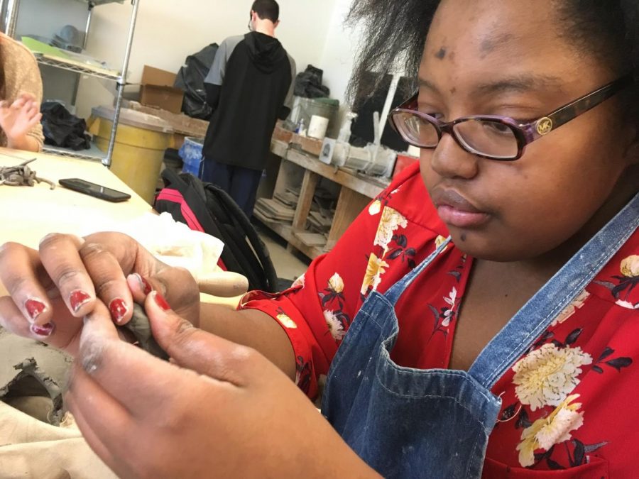 Sculpting with clay, sophomore Mercy Karioki focuses on creating her new piece.