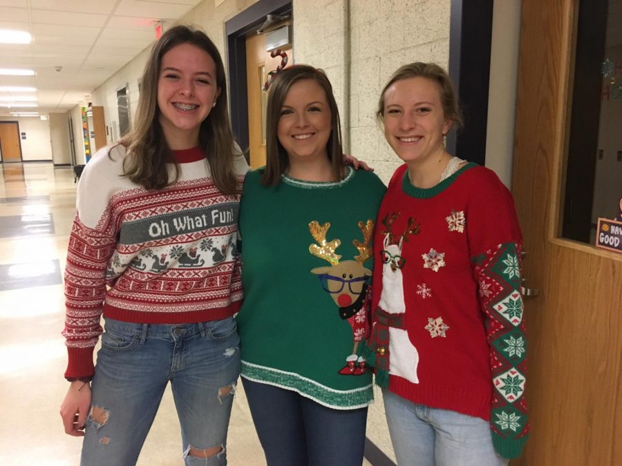 Senior Emily Philbrook, math teacher Lauren Hesemeyer and senior Elsa Ray pose together with their festive sweaters.