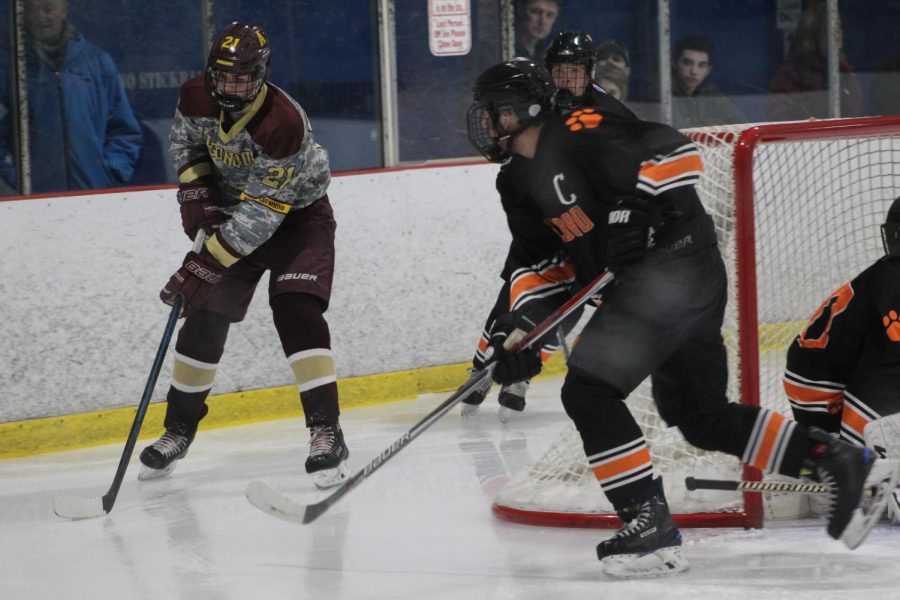 Junior Henry Alford gains control of the puck, as Marlborough plays defense. 