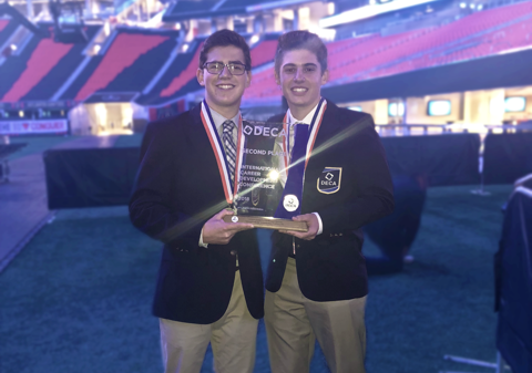 Seniors Josh Harmon and Sam Forbush hold their second place trophy at the Mercedes Benz stadium at ICDC last year.