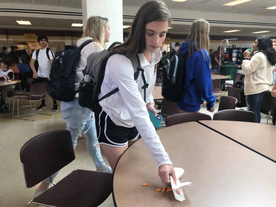 Junior Lauren Robert cleans up her lunch table as she comes in to third lunch.