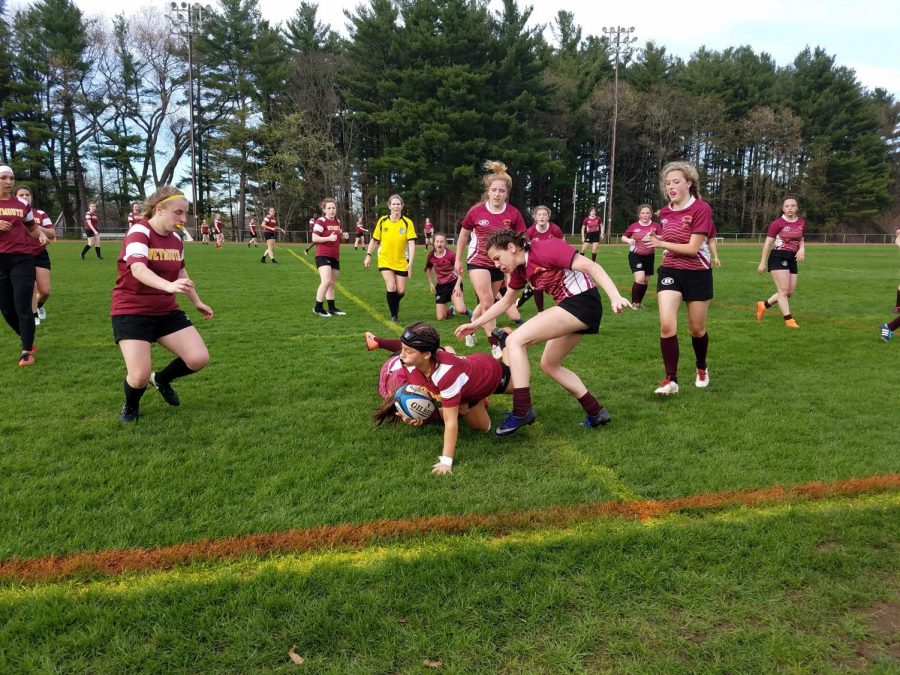 Senior Lydia Grist (ground, center), junior Kailey Carlton (right, center), junior Olivia Lamy (center, back) and sophomore Victoria Witkowski (right) play rugby against Weymouth.