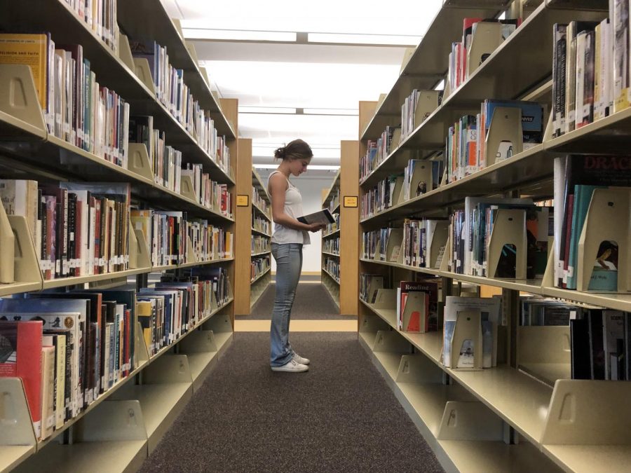 Senior Abby Thorup explores the library aisles in search of a good read.