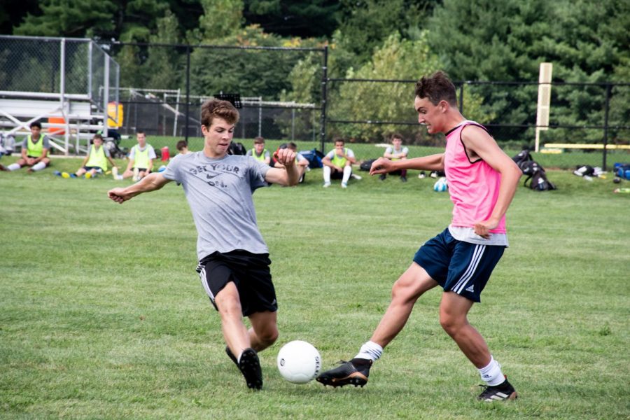 Junior Jacob Carrulli and senior Jake Piotrowski fight for possession of the ball in order to move it towards their opponents goal.