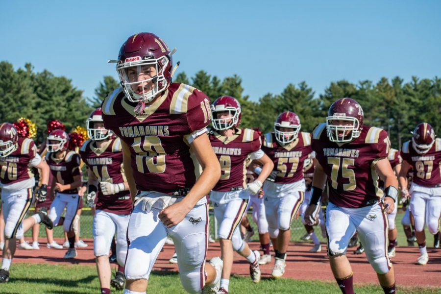 Members of the football team run onto the field before their game against Groton-Dunstable on Sept. 28. The team won 41-0. Assistant Sports Editor Karthik Yalala writes that this year the team is placing an emphasis on their sportsmanship in order to improve.