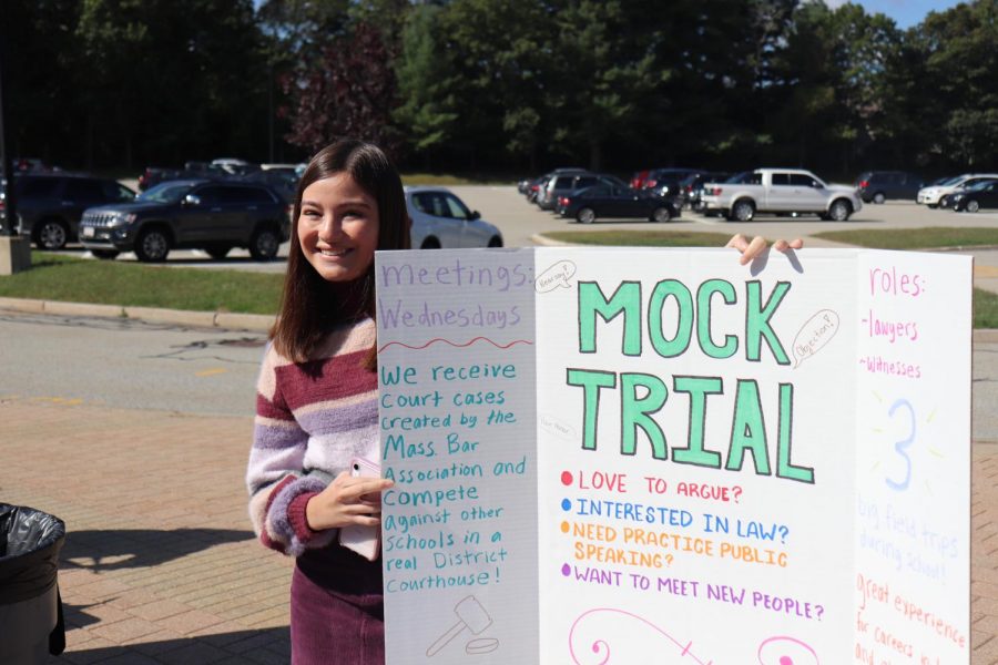 Mock Trial executive board member and junior Grace Nyberg poses with the Mock Trial poster. According to Mock Trial executive board member and junior Kyla Pelham, the club will have three main trials against different schools and only runs for half of the school year.