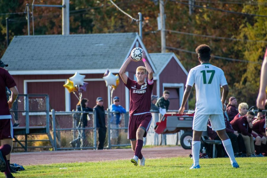 Junior captain Nick Alcock throws the ball in play against Nashoba on Oct. 26.  In addition to being a captain, Alcock has the opportunity to participate in leadership workshops held by the Athletic Council and outside workshops from the MIAA as a student ambassador.