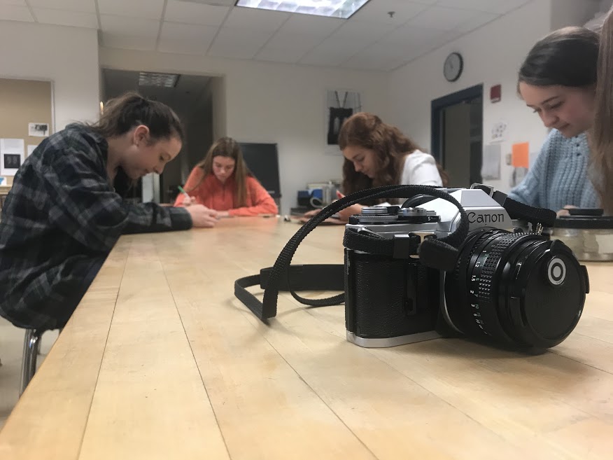 Sophomores Delaney Cosentino, Abbey Esten and Ella McRae-Spataro work in their Photo I class on critiquing each other’s contact sheets.  