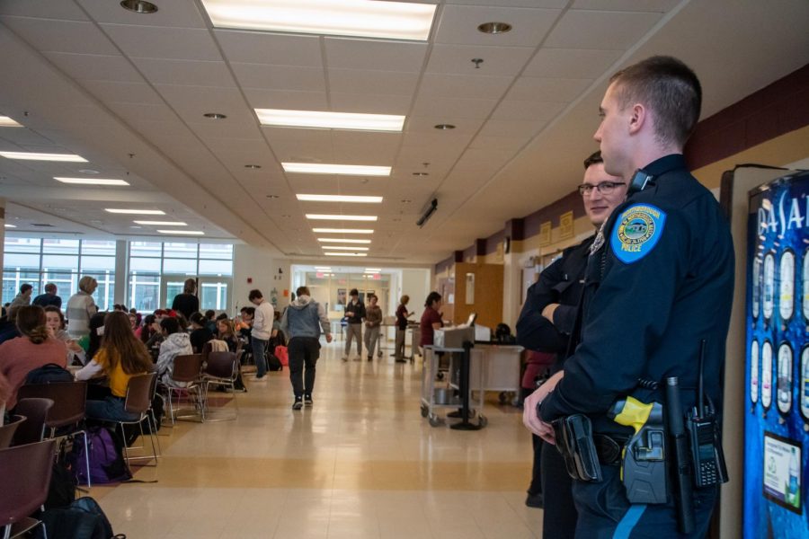 Police officers stand in the cafeteria on Dec. 10. There was an increased police presence at school after threatening statements were found written on bathroom walls.