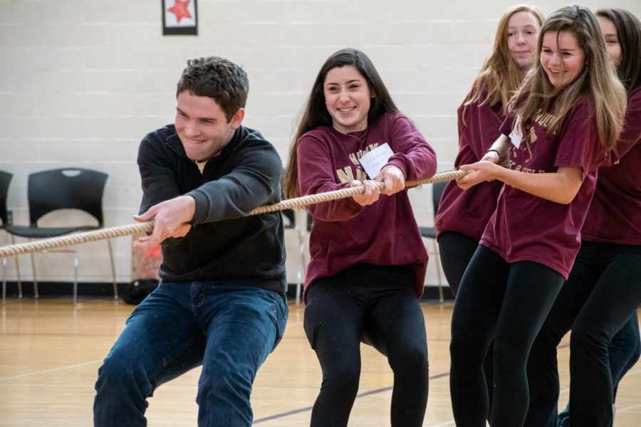[From front to back] senior Paul Probst and juniors Julia Farrell, Maeve Grandpre and Lucy McGlynn participate in a game of tug of war as a part of Day for Change. This year, more large group activities were added in order to create a more lasting impact on freshmen. 