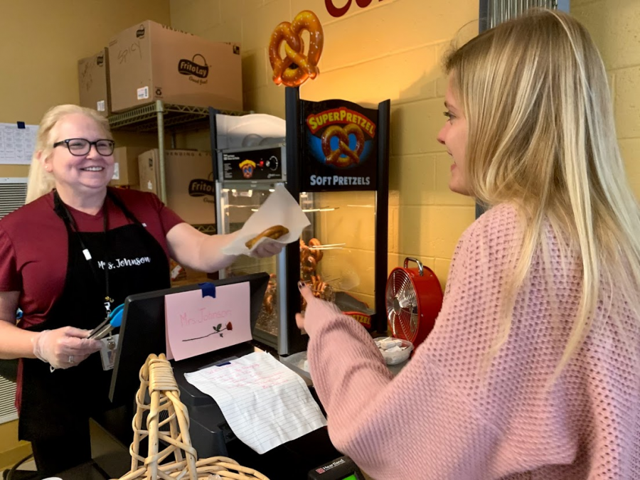 After waiting in the long line at the Corner Cafe, senior Hannah Grimm buys a pretzel from Mrs. Johnson. “Mrs. Johnson is so nice,” Grimm said. “She’s what I love about the Corner Cafe.”