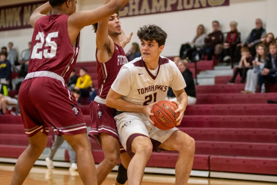 As he gets double teamed by two Fitchburg defenders, sophomore Todd Brogna looks around for teammates to pass to. Brogna put up 22 points in the 68-57 victory.