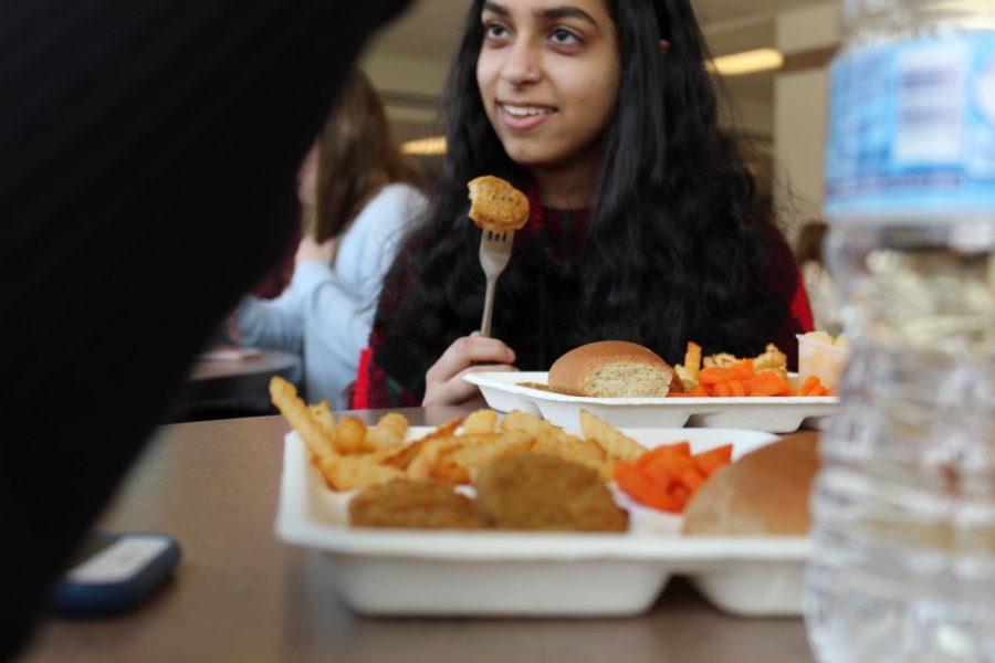 After receiving her lunch on one of the cafeteria’s new paper trays, junior Sarah Saeed enjoys her chicken nuggets.