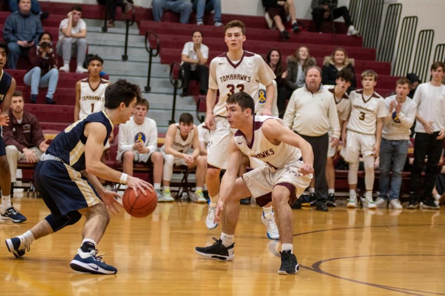 As time closes down at the end of the second quarter, senior Jack Hanna closely defends a Shrewsbury player as the Algonquin bench looks on.