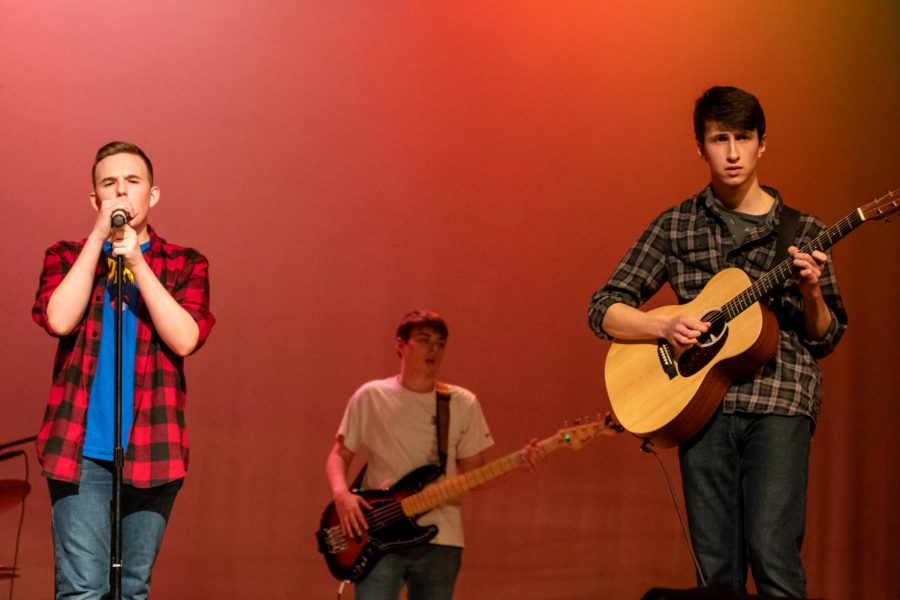 [From left to right] freshman Daniel Bousch and sophomores Connor Vietch and Ben Guggina perform at the Variety Show on Feb. 13.  These three and sophomores Evan Clifford and Thomas Davis make up the band Autumn Roots. 