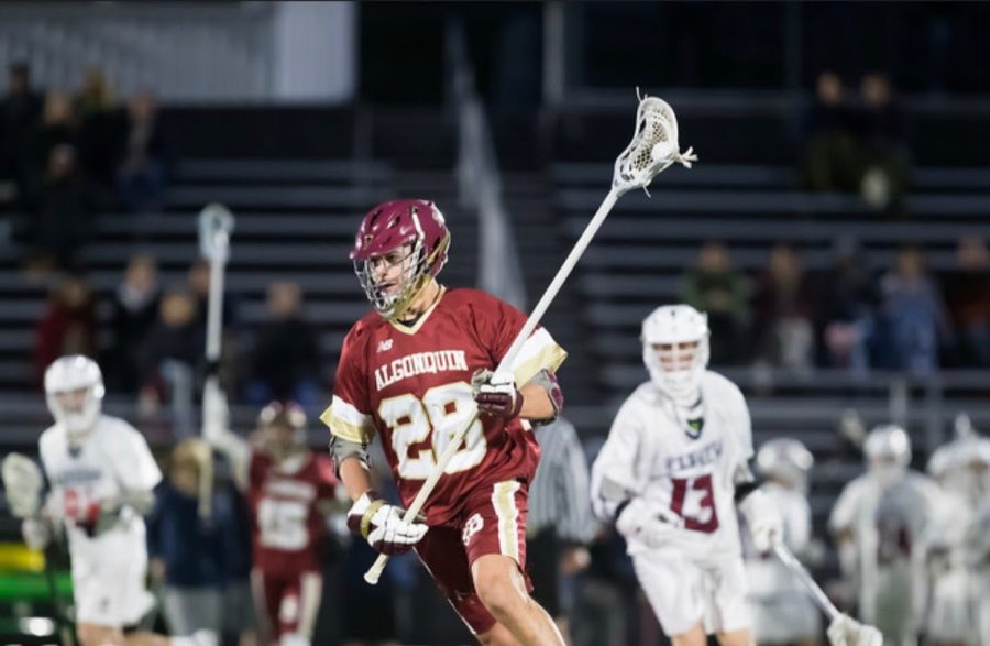 In a game under the lights, senior Will Paglia cradles the lacrosse ball and moves toward the goal.