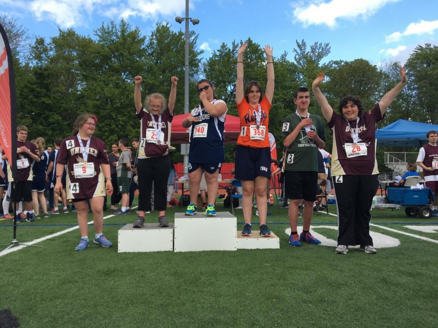 Unified track team members pose on the podium after a meet. "This is one of my favorite pictures," senior Halle Zides said.